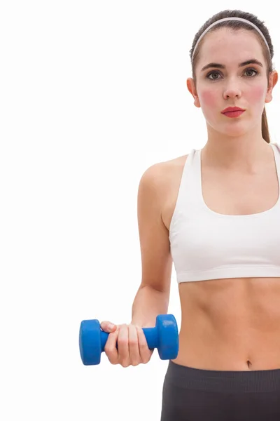 Fit brunette holding blue dumbbell — Stock Photo, Image