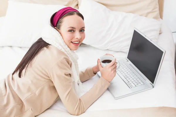 Hübsche Brünette mit Laptop auf dem Bett — Stockfoto