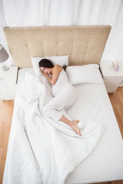 Morena grávida dormindo na cama — Fotografia de Stock