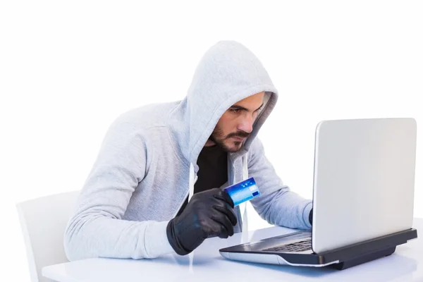 Inbrottstjuv gör online shopping med laptop och kreditkort — Stockfoto