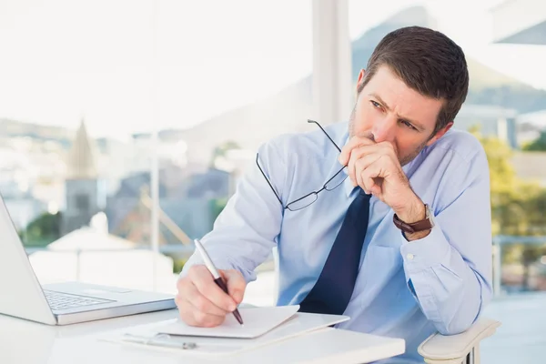 El hombre de negocios preocupado escribiendo en es bloc de notas — Foto de Stock