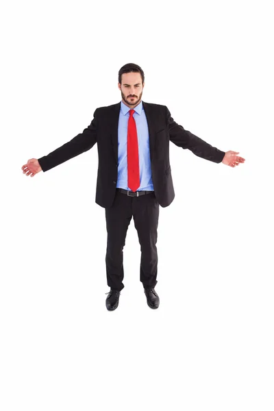 Uomo d'affari sorridente in piedi con le braccia tese — Foto Stock