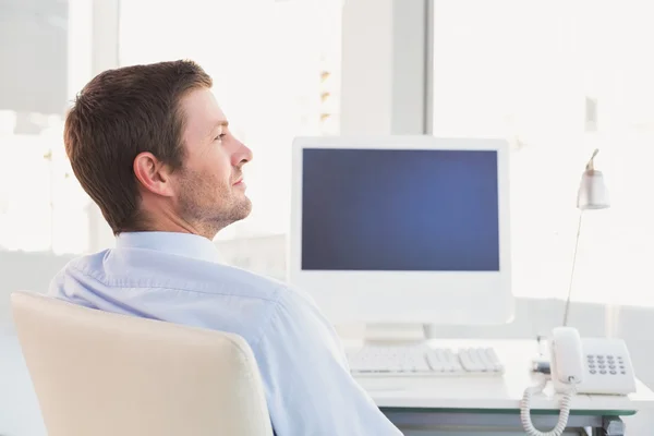 Lachende zakenman zit aan zijn Bureau — Stockfoto