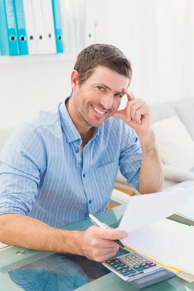 Lachende zakenman bezig met zijn financiën op zijn Bureau — Stockfoto