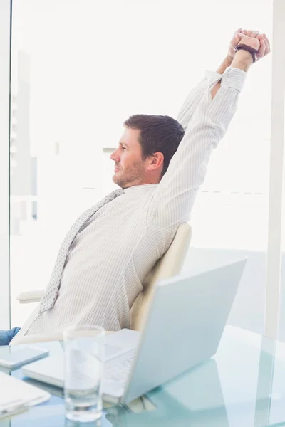 A businessman stretching in swivel chair — Stock Photo, Image