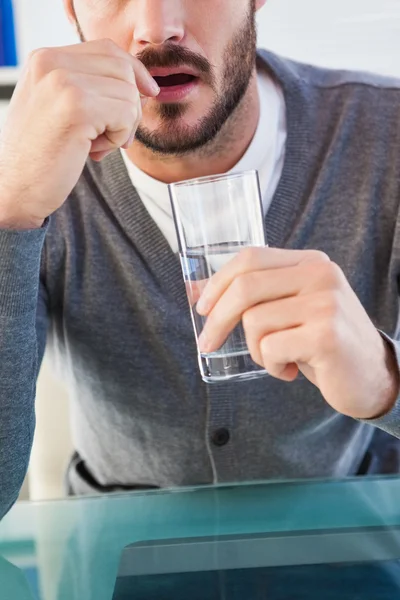 Partie médiane d'un homme avec verre d'eau et pilule — Photo