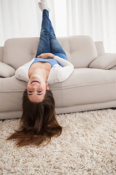 Красивая брюнетка лежит вверх ногами на диване — стоковое фото