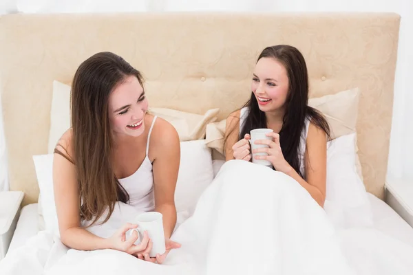 Pretty friends having coffee in bed — Stock Photo, Image
