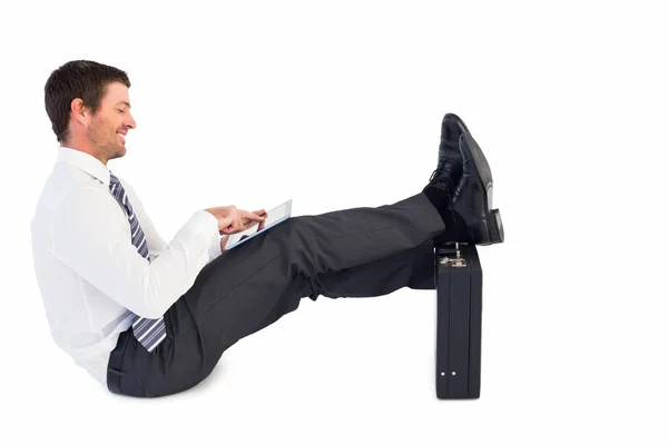 Businessman with feet up on briefcase — Stock Photo, Image