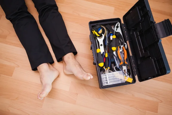 Handyman acostado descalzo en el suelo con herramientas de bricolaje —  Fotos de Stock