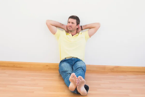 Казуальный человек, сидящий дома на полу — стоковое фото
