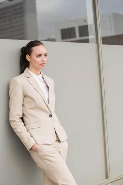 Young businesswoman leaning against wall — Stock Photo, Image