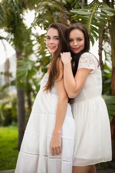 Красивые друзья, улыбающиеся в белых платьях — стоковое фото