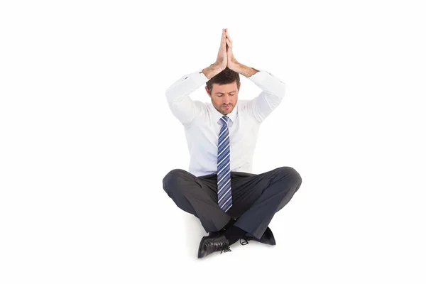 Businessman sitting in lotus pose with hands together — Stock Photo, Image