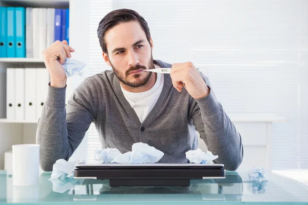 Thoughtful businessman holding pen at desk — Stock Photo, Image