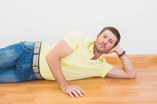 Homem deitado no chão em casa — Fotografia de Stock