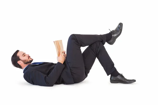 Empresario tirado en el suelo leyendo un libro — Foto de Stock