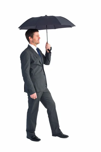 Geschäftsmann versteckt sich unter schwarzem Regenschirm — Stockfoto