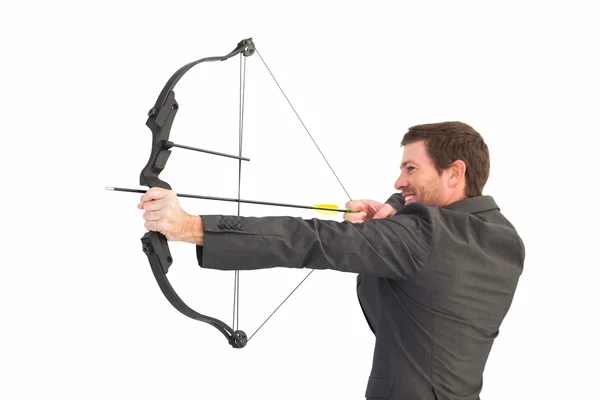 Handsome businessman shooting a bow and arrow — Stock Photo, Image