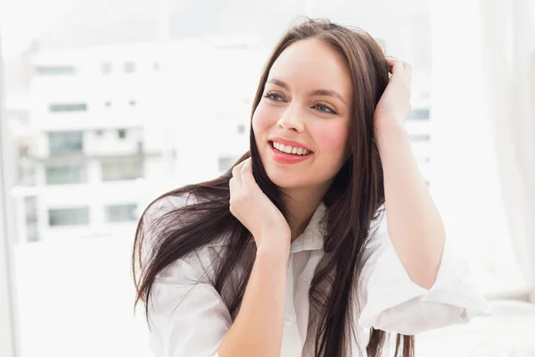 Mooie brunette glimlachen op bed — Stockfoto