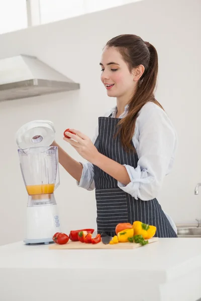 Pretty brunette making a healthy juice — Stock Photo, Image