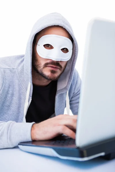 Man bär mask medan hacka in i laptop — Stockfoto