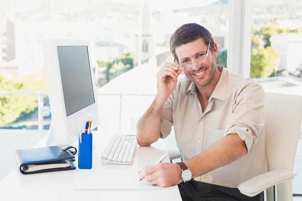 Sonriente hombre de negocios casual trabajando en su escritorio — Foto de Stock