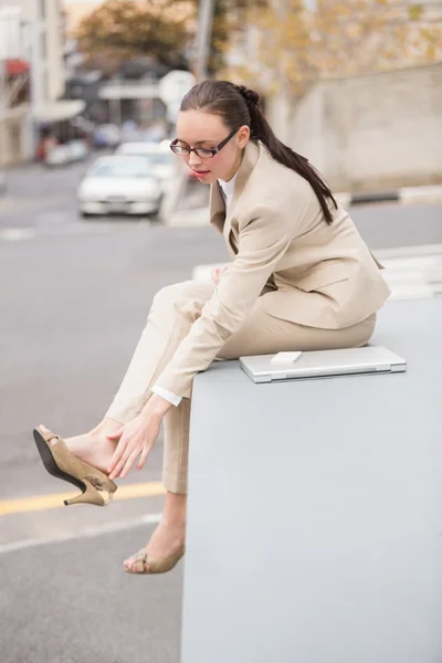 Young businesswoman adjusting her shoe — Stock Photo, Image