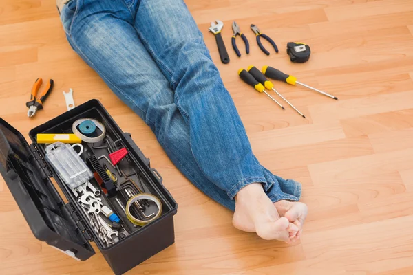 Piernas de hombre con caja de herramientas en el suelo en casa — Foto de Stock