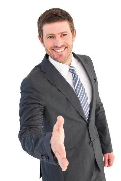 Бизнесмен улыбается и протягивает руку — стоковое фото