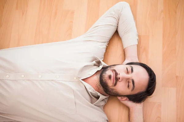 Young man lying on floor thinking — Stock Photo, Image