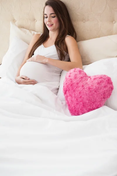 Yatakta oturmuş hamile esmer — Stok fotoğraf