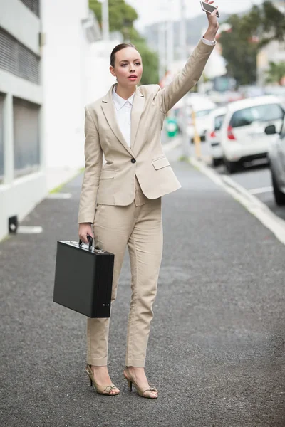 Jeune femme d'affaires qui appelle un taxi — Photo