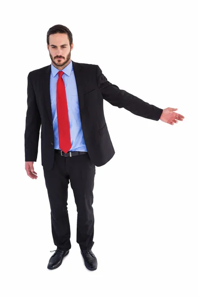 Unsmiling businessman showing something with his hand — Stock Photo, Image