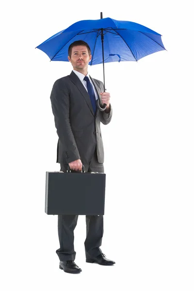 Homme d'affaires sérieux tenant son parapluie et sa mallette — Photo