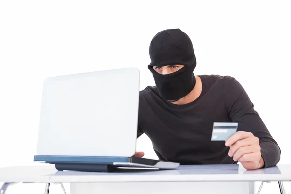 Burglar doing online shopping with laptop and credit card — Stock Photo, Image