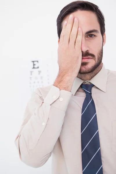 Lächelnder Patient, der mit einem Auge in die Kamera blickt — Stockfoto