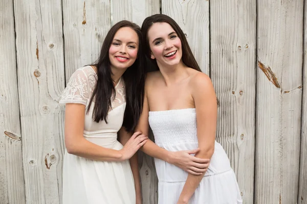 Красивые друзья, улыбающиеся в белых платьях — стоковое фото
