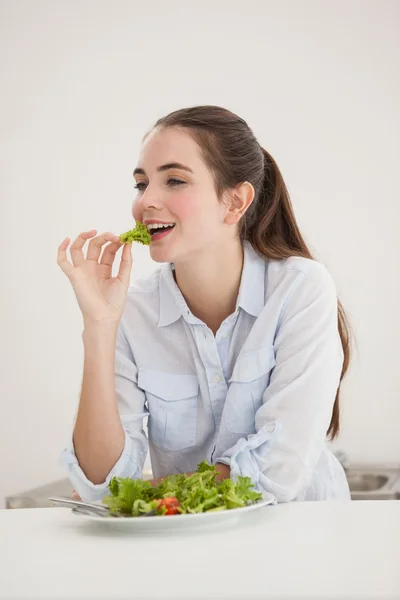 Bonita morena comendo tigela de salada — Fotografia de Stock