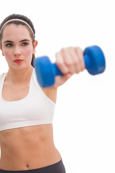 Fit brunette holding blue dumbbell — Stock Photo, Image