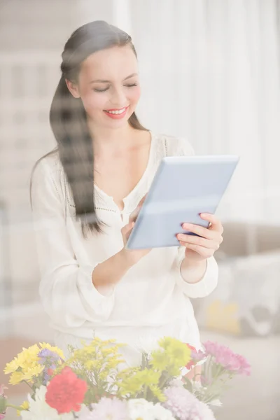 Pretty brunette using her tablet — Stock Photo, Image