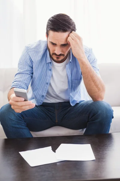 Homem preocupado segurando seu telefone — Fotografia de Stock