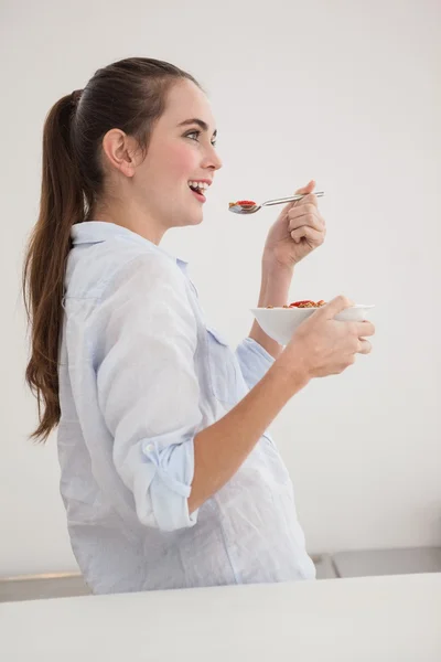 Mooie brunette eten kom van granen — Stockfoto