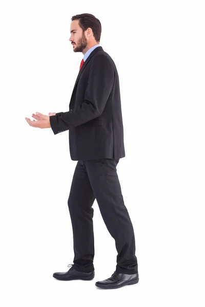 Businessman walking and presenting with hands — Stock Photo, Image
