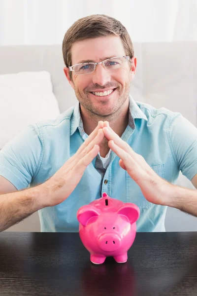 Hombre sonriente con alcancía — Foto de Stock