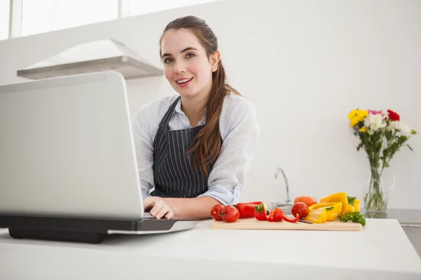 Morena bonita siguiendo receta en línea —  Fotos de Stock