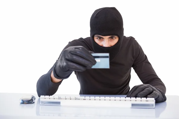 Burglar doing online shopping with laptop and credit card — Stock Photo, Image