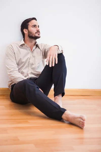 Casual doordachte man leunend tegen muur opzoeken — Stockfoto