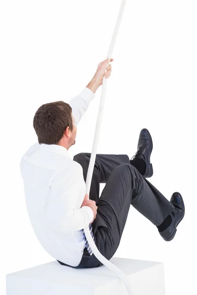 Businessman pulling a rope with effort — Stock Photo, Image