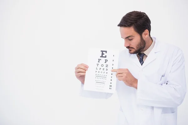 Docteur en blouse de laboratoire montrant un test oculaire — Photo